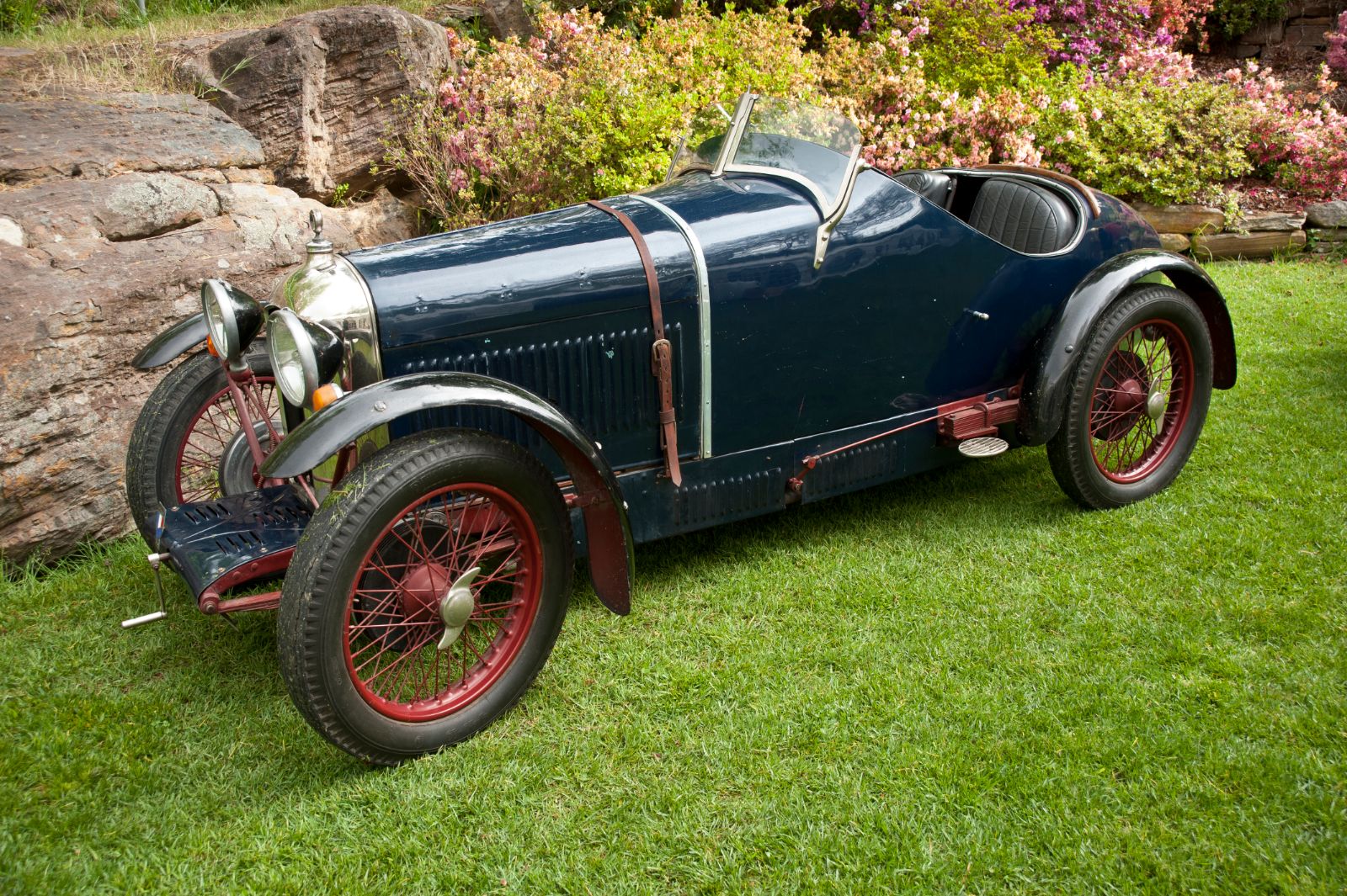 Blue Amilcar CGS with red wire wheels on a lawn